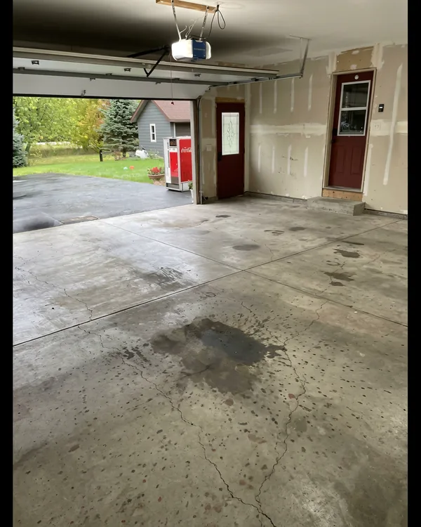 Before photo of a Frisco garage with stained concrete and unfinished-looking floor