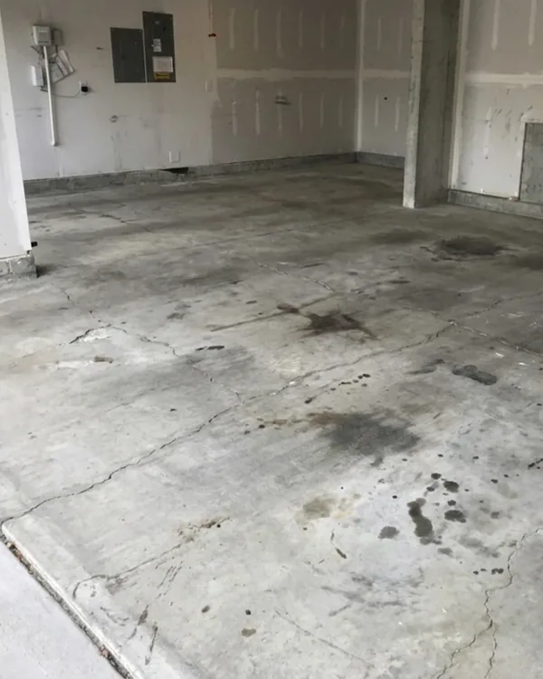 Before photo of a McKinney garage with stained concrete and visible cracking