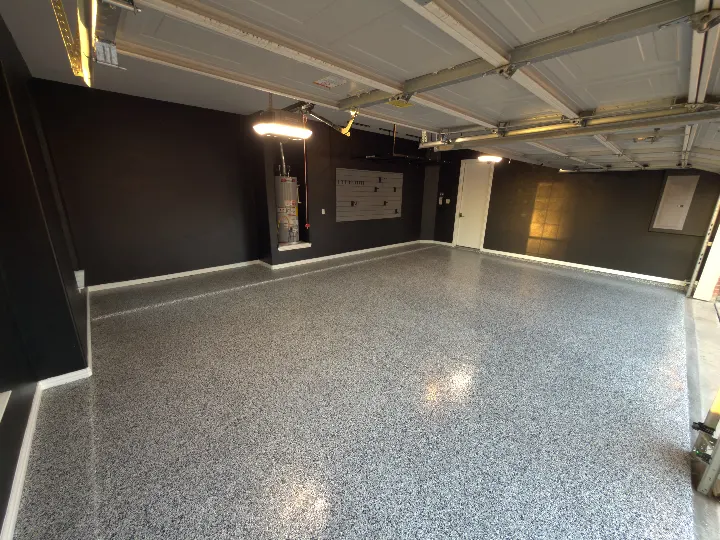 Completed garage remodel in Lewisville Texas with Domino flake flooring and black painted walls.